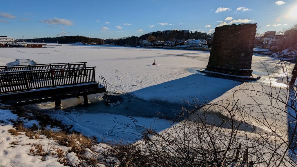 Old Stocksundsbro bridge support with a small bathing platform and an ice hole