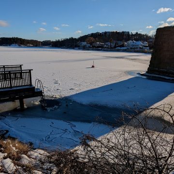 Old Stocksundsbro bridge support with a small bathing platform and an ice hole
