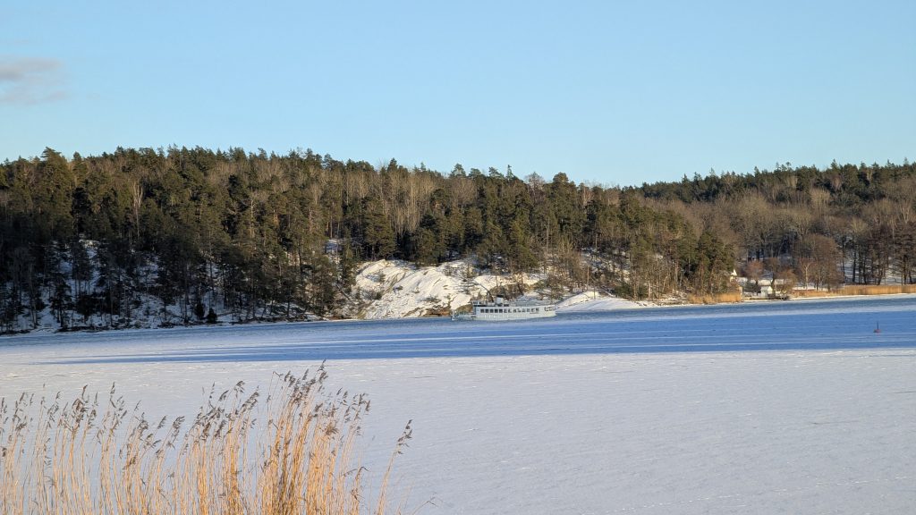 Small passenger boat crossing frozen bay in Stocksund